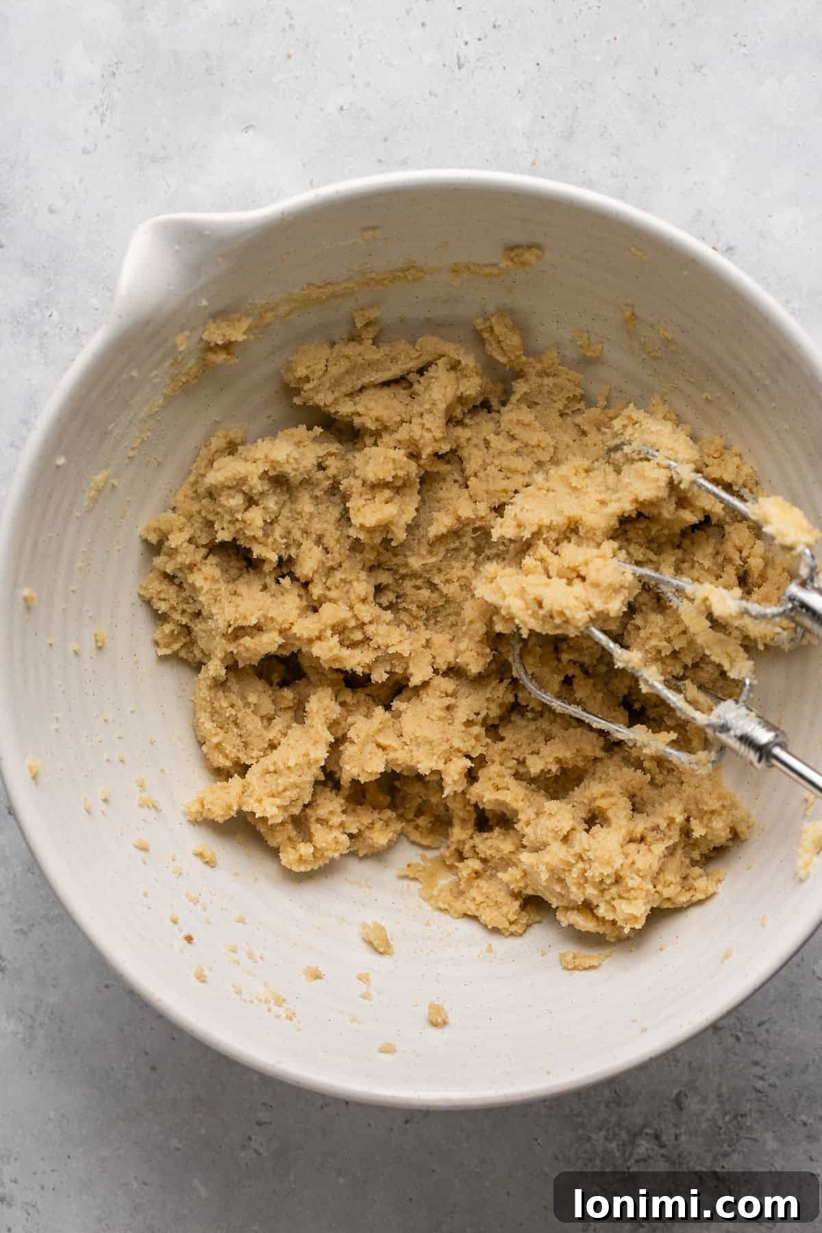 Creamed butter and sugars, light and fluffy, in a bowl.