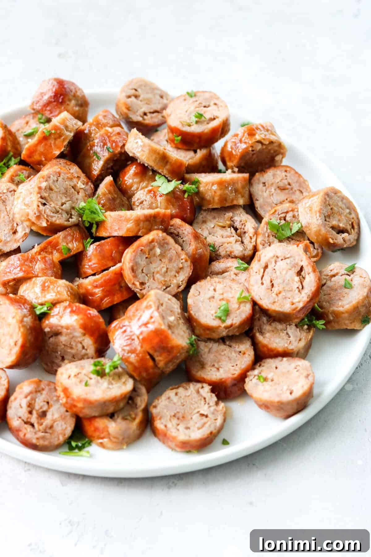 Sliced Italian sausages on a white plate, garnished with fresh parsley.