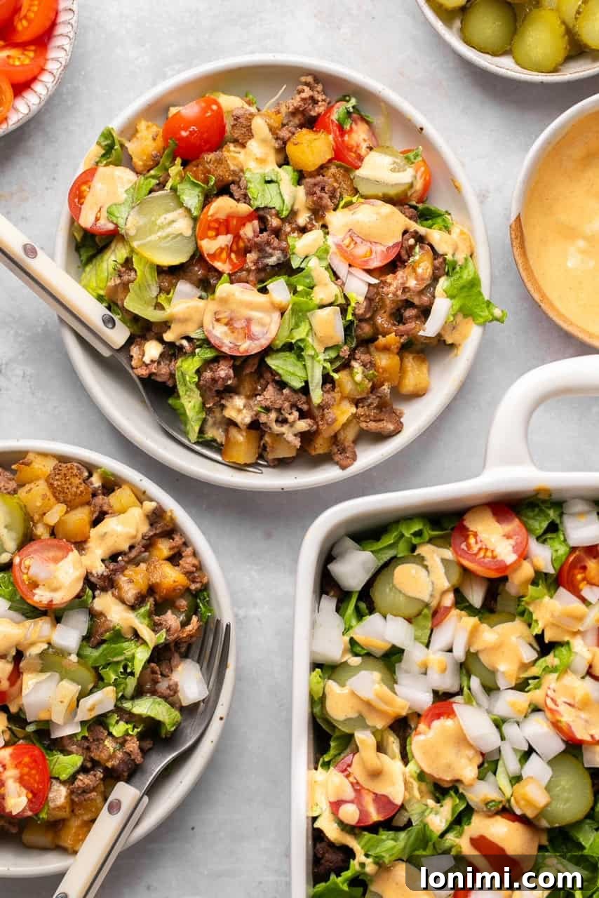 Two bowls of Big Mac Casserole, perfectly portioned and ready to be served, highlighting the delicious layers and fresh toppings.