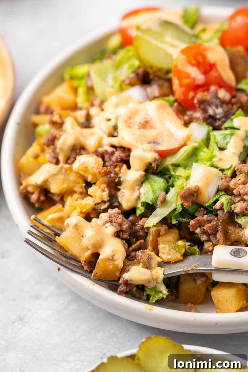 A close-up view of the delicious Big Mac Casserole, showcasing the texture of the ground beef and potatoes, with a hint of sauce, lettuce, and tomato.