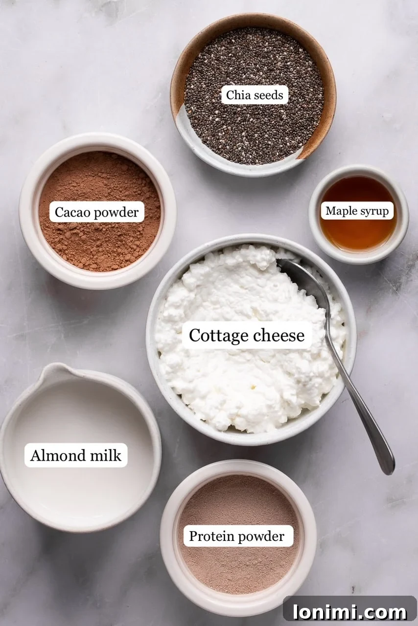 Ingredients for protein chia seed pudding arranged on a counter in small bowls, including chia seeds, protein powder, cacao, cottage cheese, almond milk, and maple syrup.
