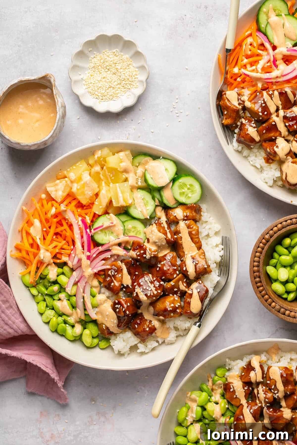 Effortless Teriyaki Chicken Poke Bowls with Fiery Sriracha Mayo 7 Chicken poke bowls with toppings surrounded by small bowls of garnishes