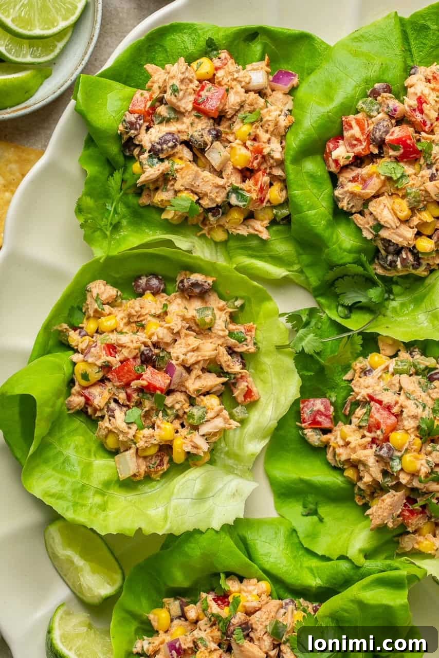 Vibrant Healthy Mexican Tuna Salad 2 Vibrant Mexican tuna salad served in crisp butter lettuce cups, garnished with a lime wedge.