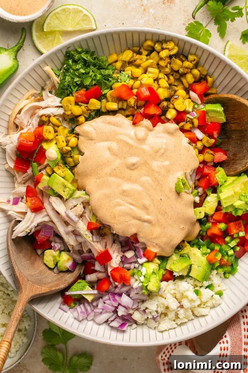 The creamy cilantro lime crema drizzled generously over the mixed salad ingredients before tossing