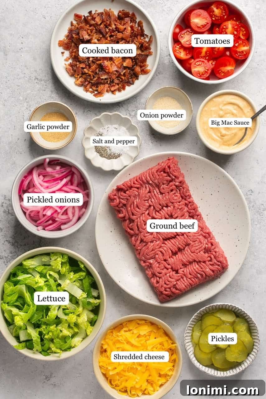 Bacon Cheeseburger Bowls Big Mac Style 3 Ingredients for healthy cheeseburger bowls neatly arranged in nesting bowls, including ground beef, spices, red onion, lettuce, tomatoes, cheese, bacon, and pickles.