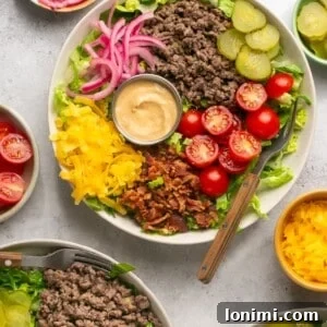 cheeseburger bowls with ground beef, veggies, pickled onions, and Big Mac Sauce surrounded by bowls of toppings