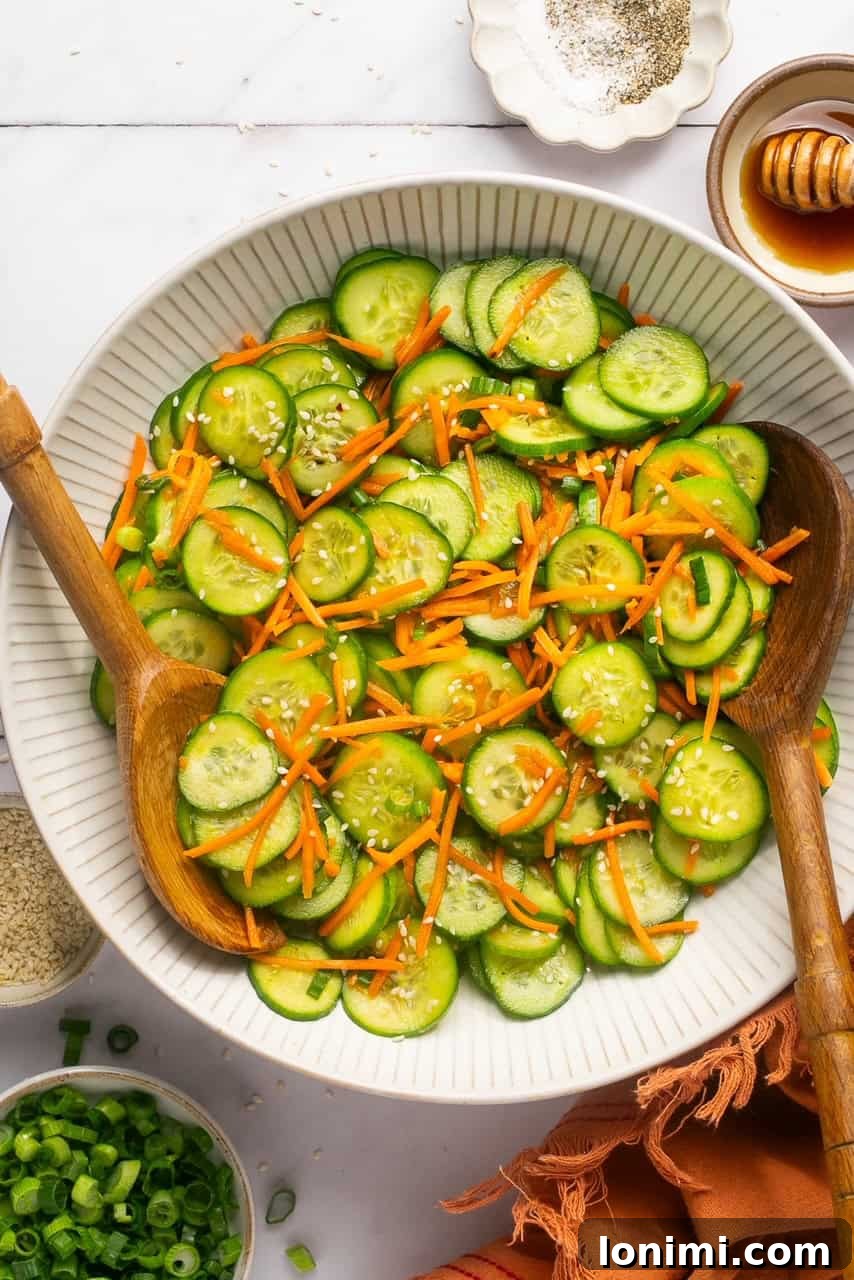 two wooden spoons resting on the side of a salad bowl filled with fresh veggies