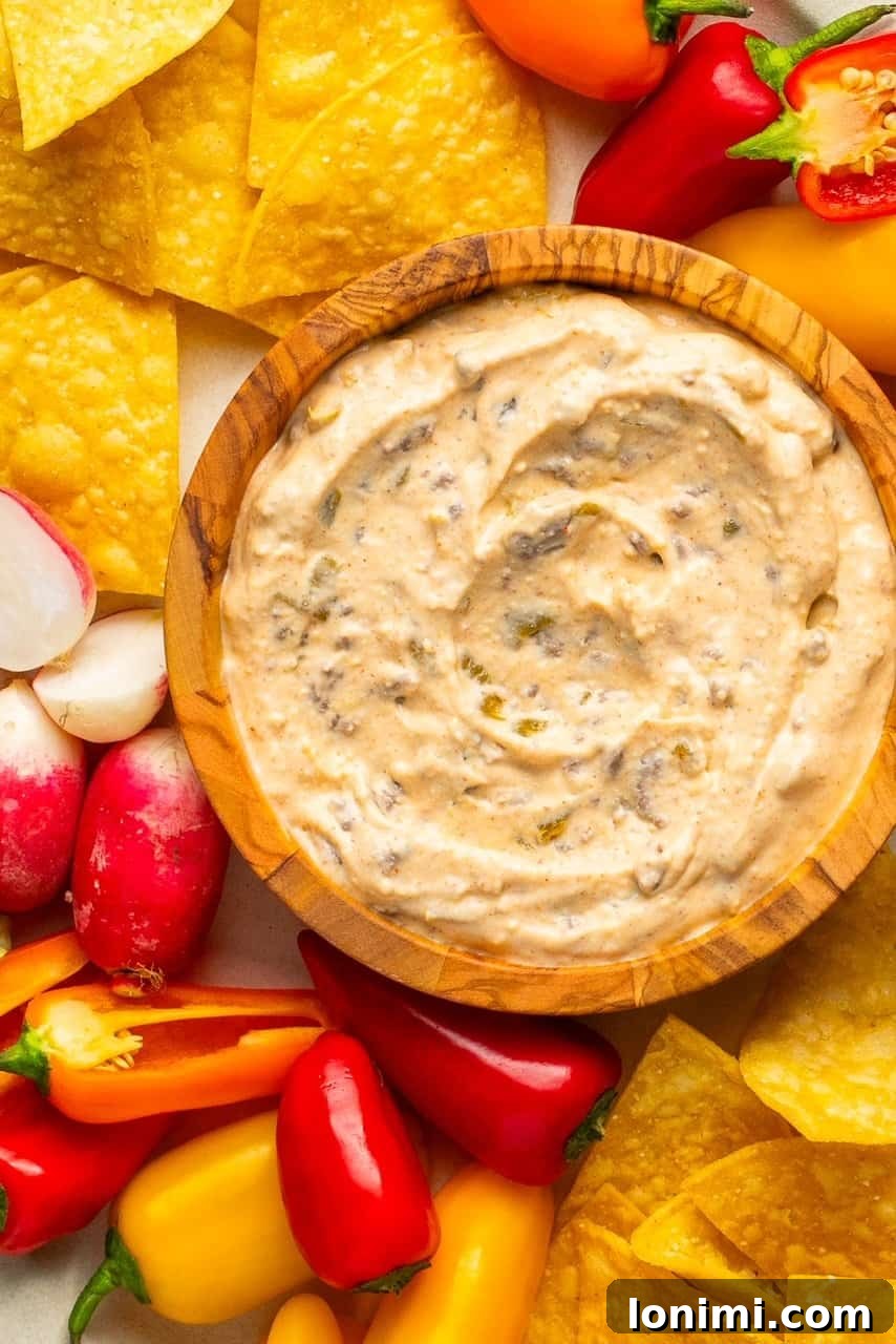 The Viral Protein-Packed Cottage Cheese Queso 5 A delectable close-up shot of high-protein cottage cheese queso served in an elegant wooden bowl, emphasizing its rich, smooth texture and savory components.