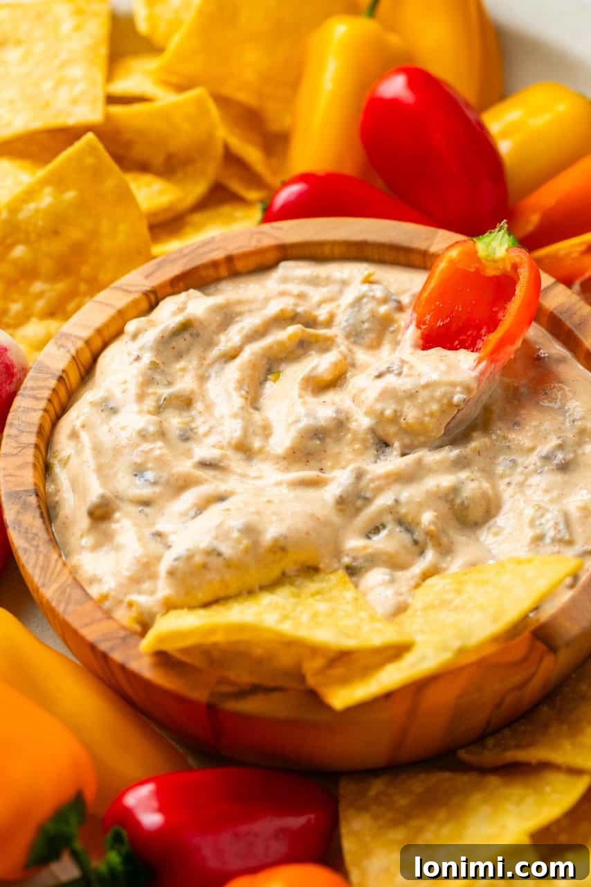 The Viral Protein-Packed Cottage Cheese Queso 6 A vibrant mini bell pepper being dipped into a luscious, creamy high-protein cottage cheese queso, showcasing a healthy and delicious snack.