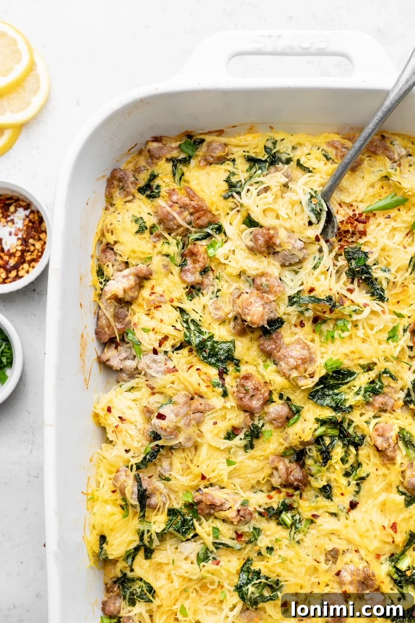 A beautiful Tuscan Spaghetti Squash Casserole, steaming hot and ready to serve, a perfect blend of roasted squash, savory sausage, and fresh kale in a rich, dairy-free garlic sauce.