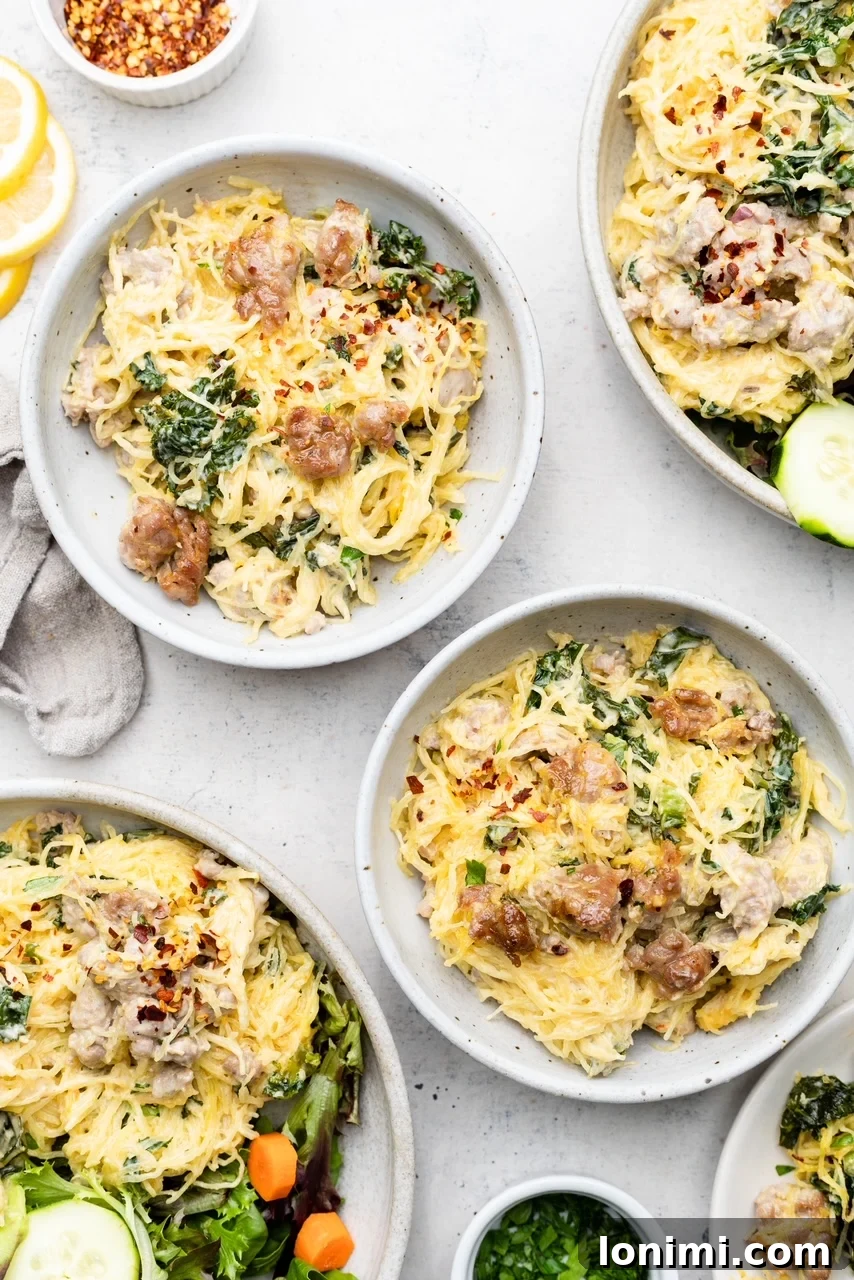 Two serving bowls filled with Tuscan spaghetti squash casserole, garnished with fresh herbs, showcasing the tender sausage, vibrant kale, and creamy squash strands.