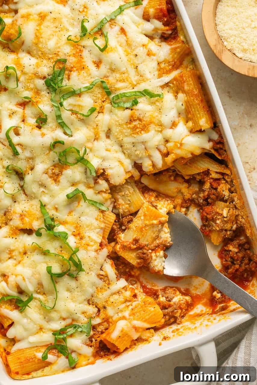 Effortless Cheesy Lasagna Bake 2 A generous serving of Lazy Lasagna scooped onto a plate, showcasing layers of pasta, meat sauce, and melted cheese.