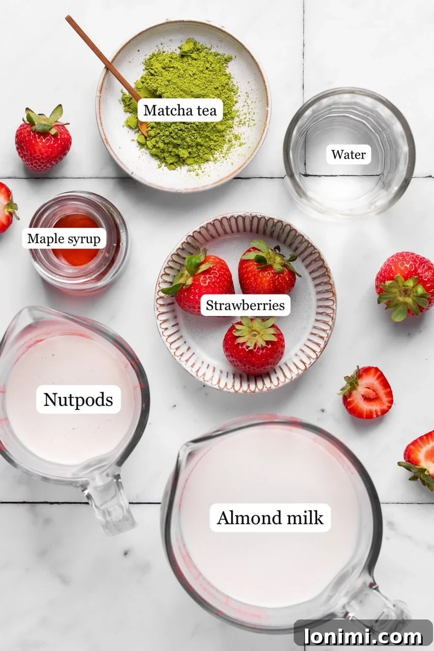 Individual bowls of matcha powder, fresh strawberries, maple syrup, and creamer, ready for the iced strawberry matcha latte recipe.