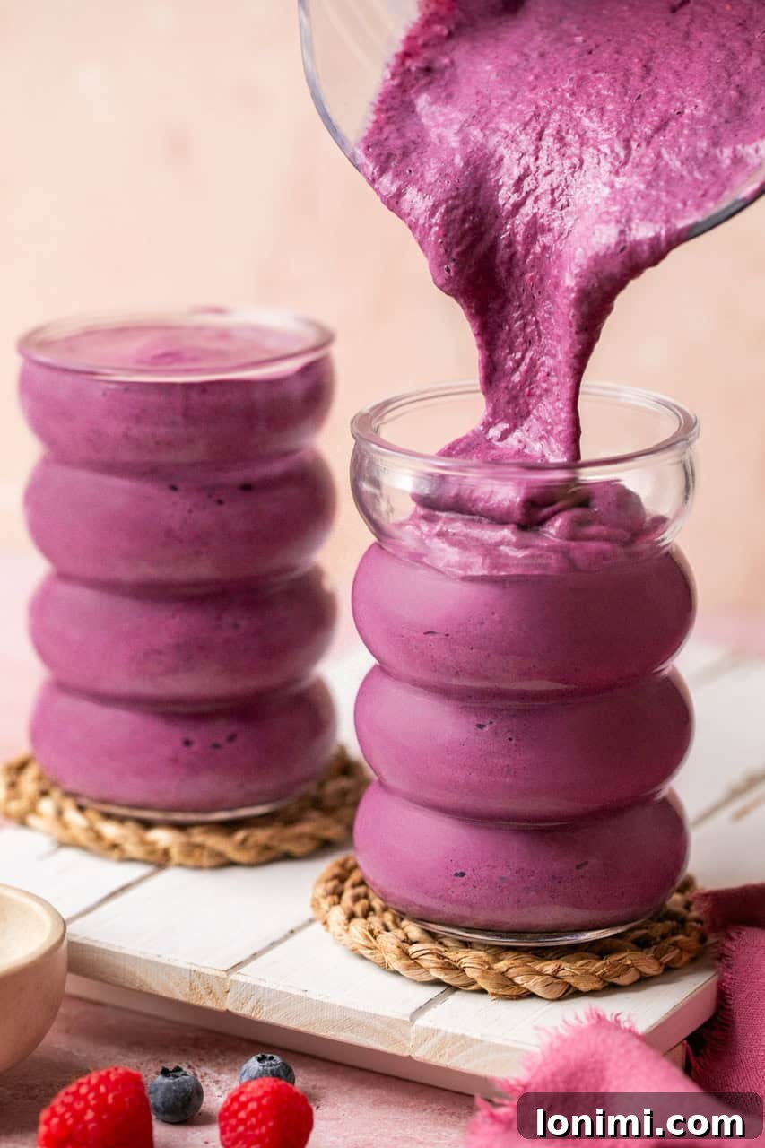Berry Bliss Cottage Cheese Smoothie 6 pouring a cheesecake cottage cheese smoothie into a tall glass