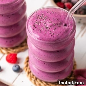 2 protein smoothies with cottage cheese and frozen berries in glass cups with glass straws