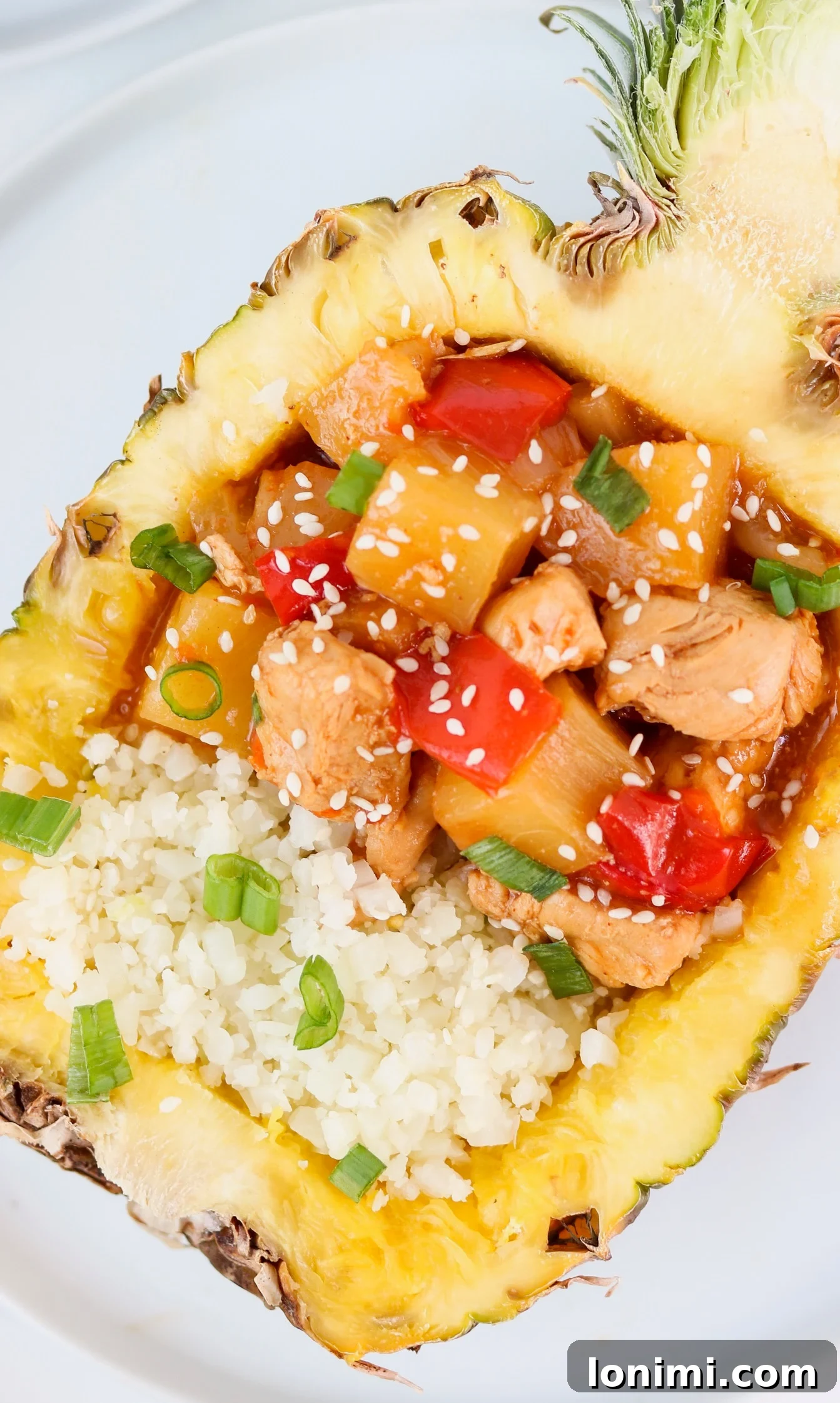 Close-up of Whole30 Instant Pot Hawaiian Chicken, showcasing tender chicken pieces, colorful red bell peppers, and onion slices coated in a glossy sauce.