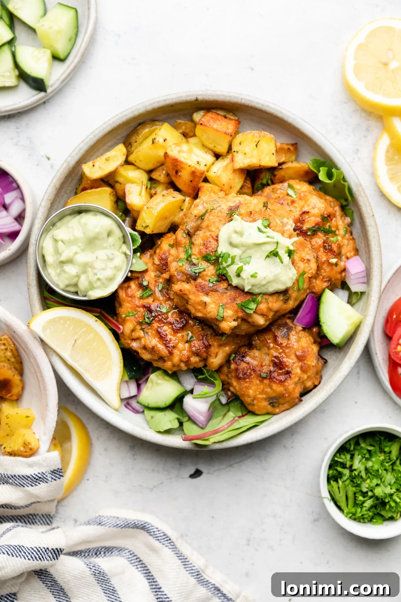 Spicy Southwest Keto Salmon Cakes with Creamy Avocado Aioli 8 A bowl with southwest salmon cakes with roasted potatoes and avocado ranch aioli
