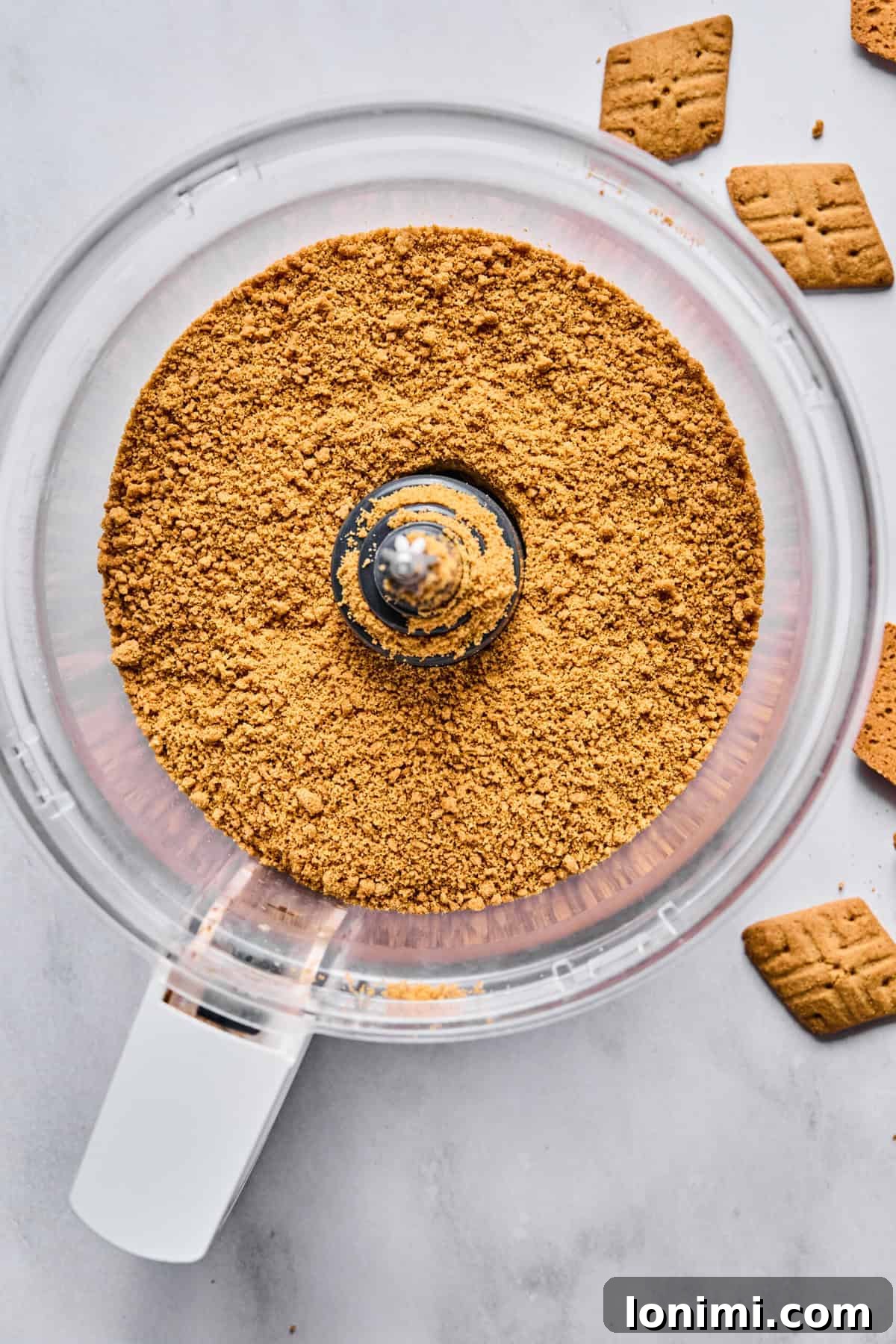 graham cracker crumbs in a food processor bowl, finely ground