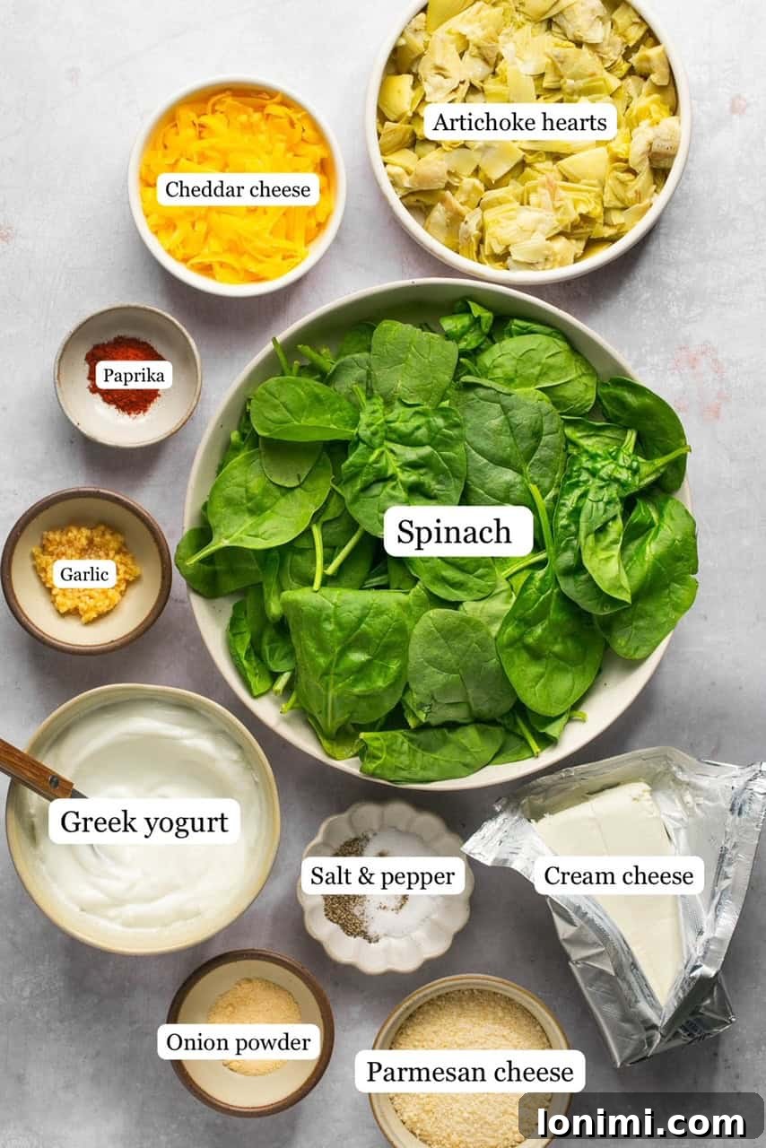 Decadent Mayo-Free Spinach Artichoke Dip 3 Recipe ingredients for spinach artichoke dip laid out in small bowls and labeled