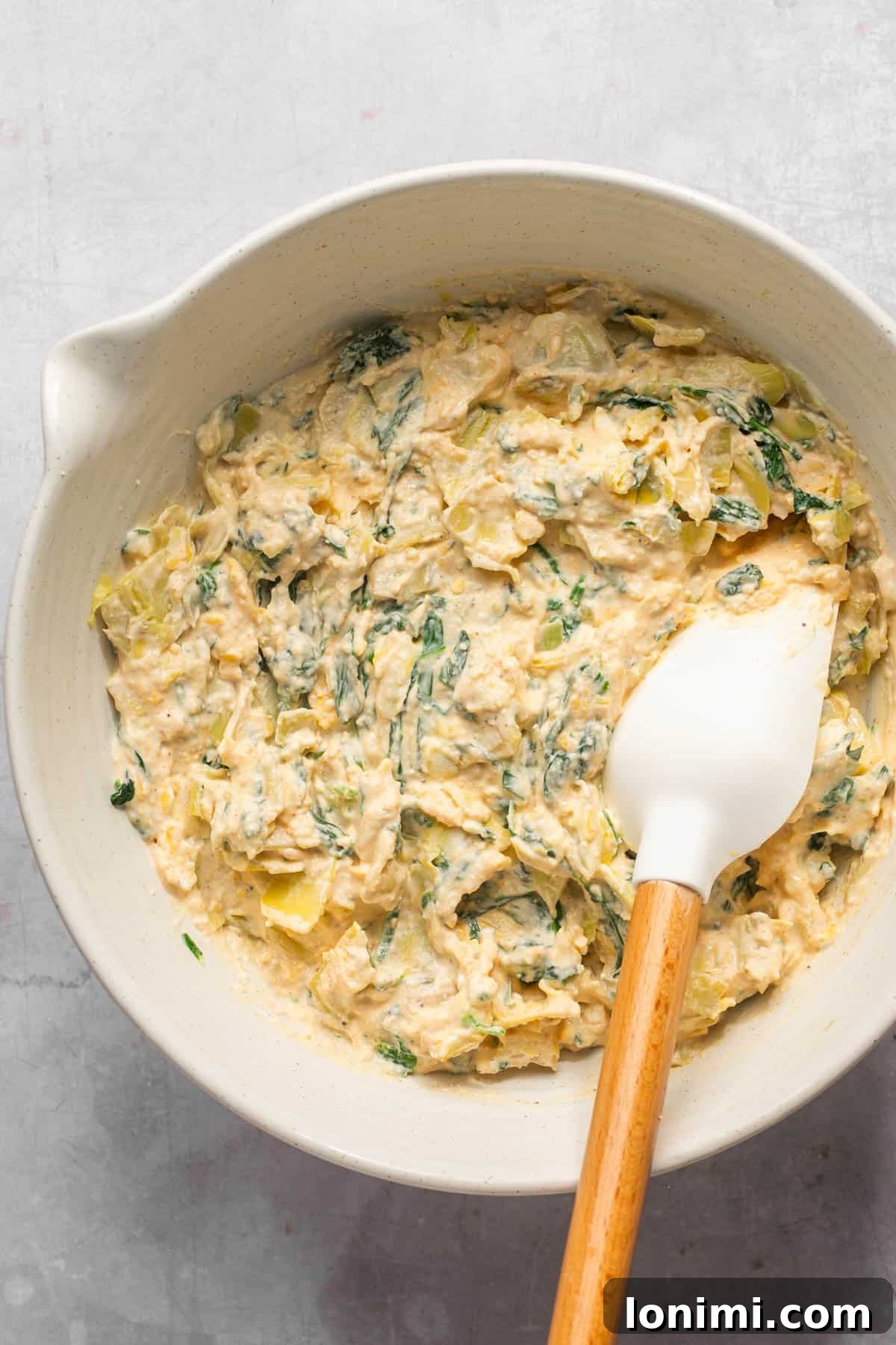 Decadent Mayo-Free Spinach Artichoke Dip 9 Spinach artichoke dip fully combined and ready for baking in a mixing bowl