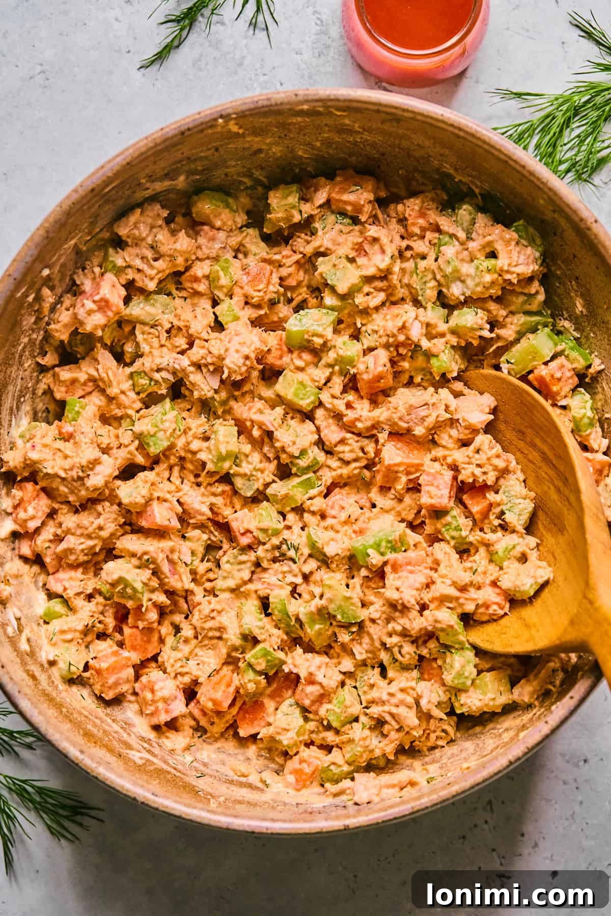 buffalo tuna salad in a pink bowl with a wooden spoon