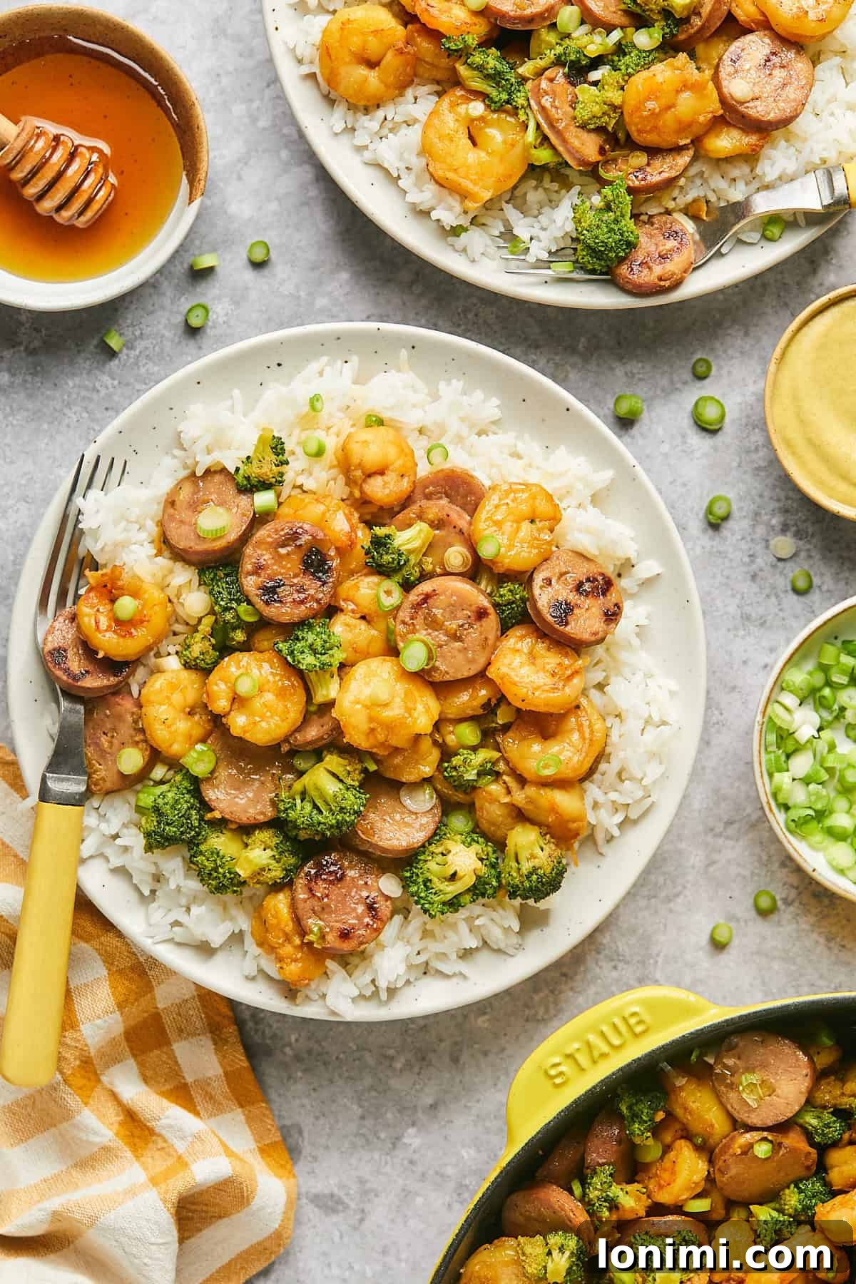 Gluten Free Hot Honey Glazed Shrimp and Sausage Stir Fry 13 Two plates of hot honey shrimp and sausage stir fry served over white rice, garnished with green onions, ready for a delicious meal.