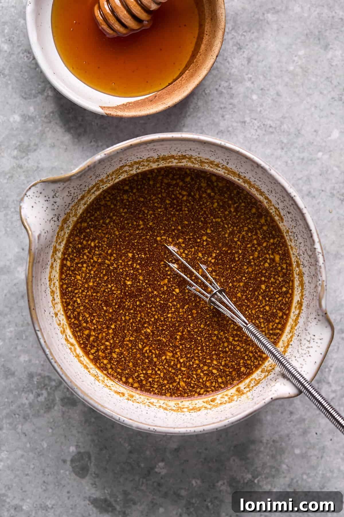 Gluten Free Hot Honey Glazed Shrimp and Sausage Stir Fry 5 The hot honey sauce mixture, a vibrant amber color, freshly whisked in a glass bowl, ready to be added to the stir-fry.