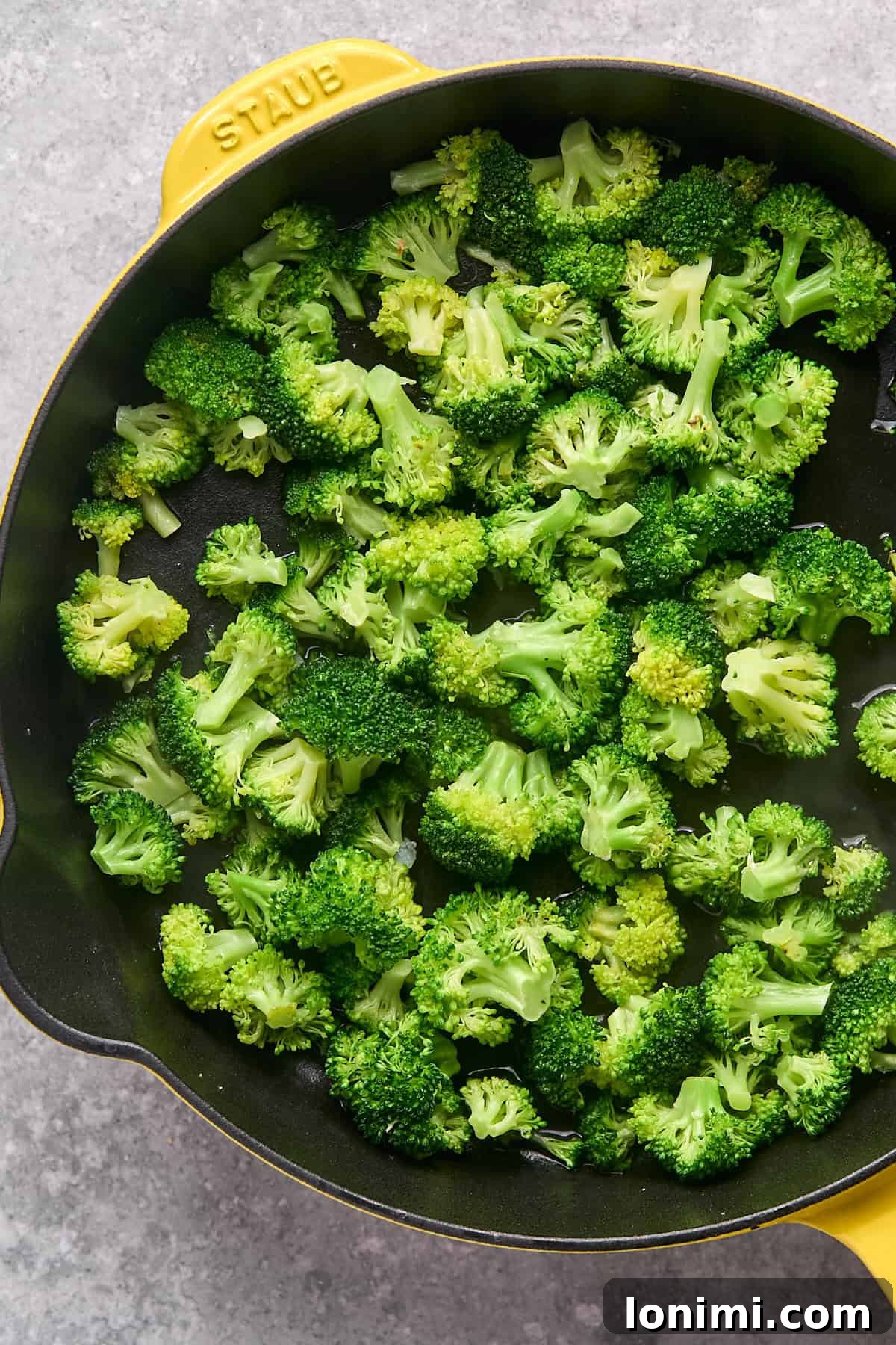 Gluten Free Hot Honey Glazed Shrimp and Sausage Stir Fry 9 Perfectly steamed, bright green broccoli florets glistening in the skillet, indicating they are fork-tender.