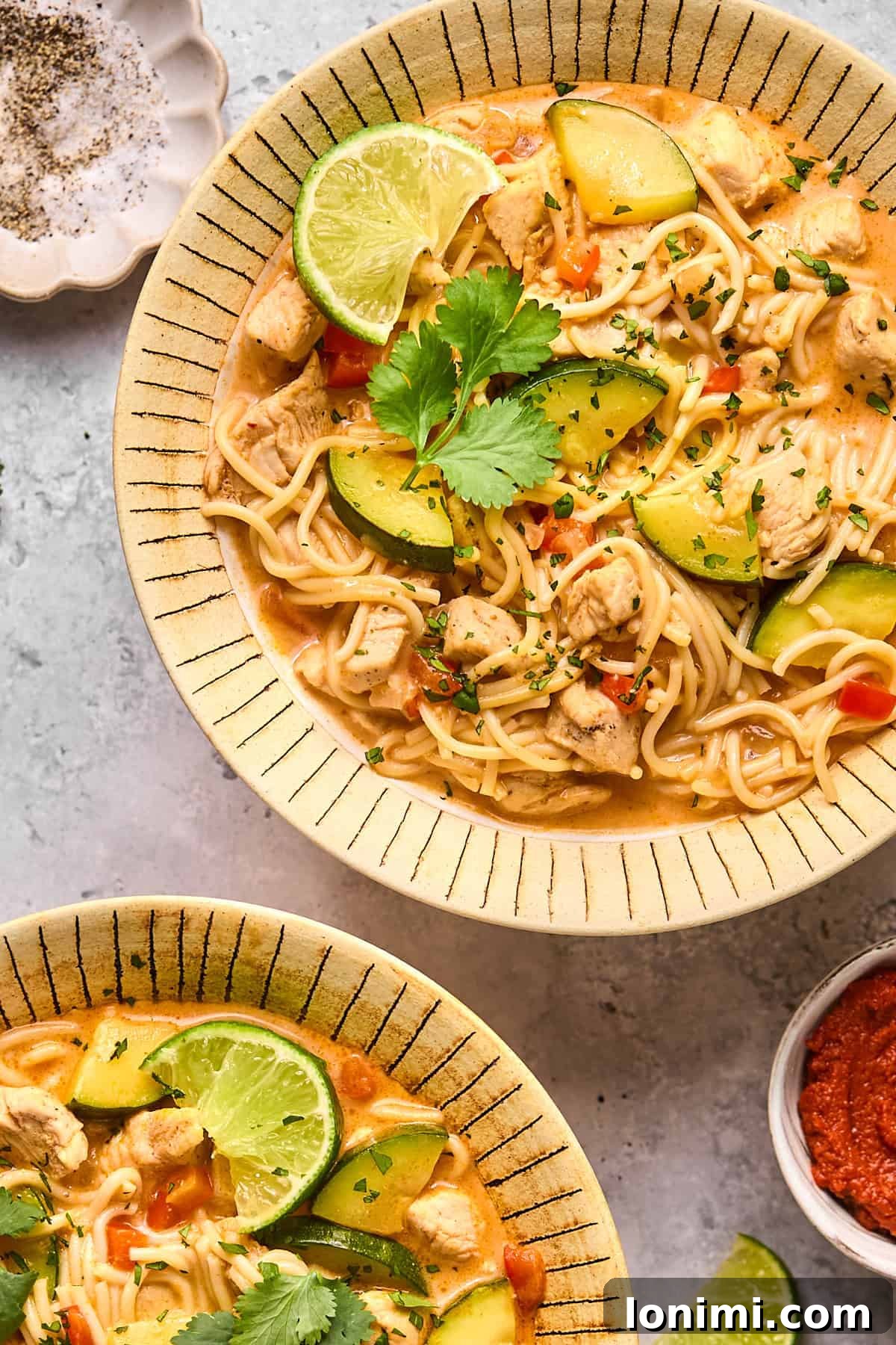 an overhead shot of red curry soup with noodles in a bowl 