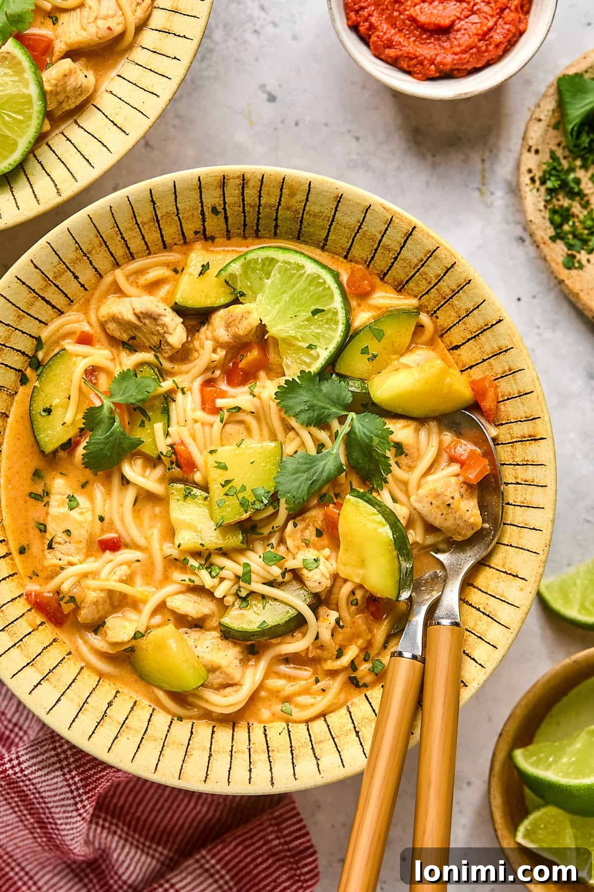 a bowl of soup with a spoon and a fork resting on the side 