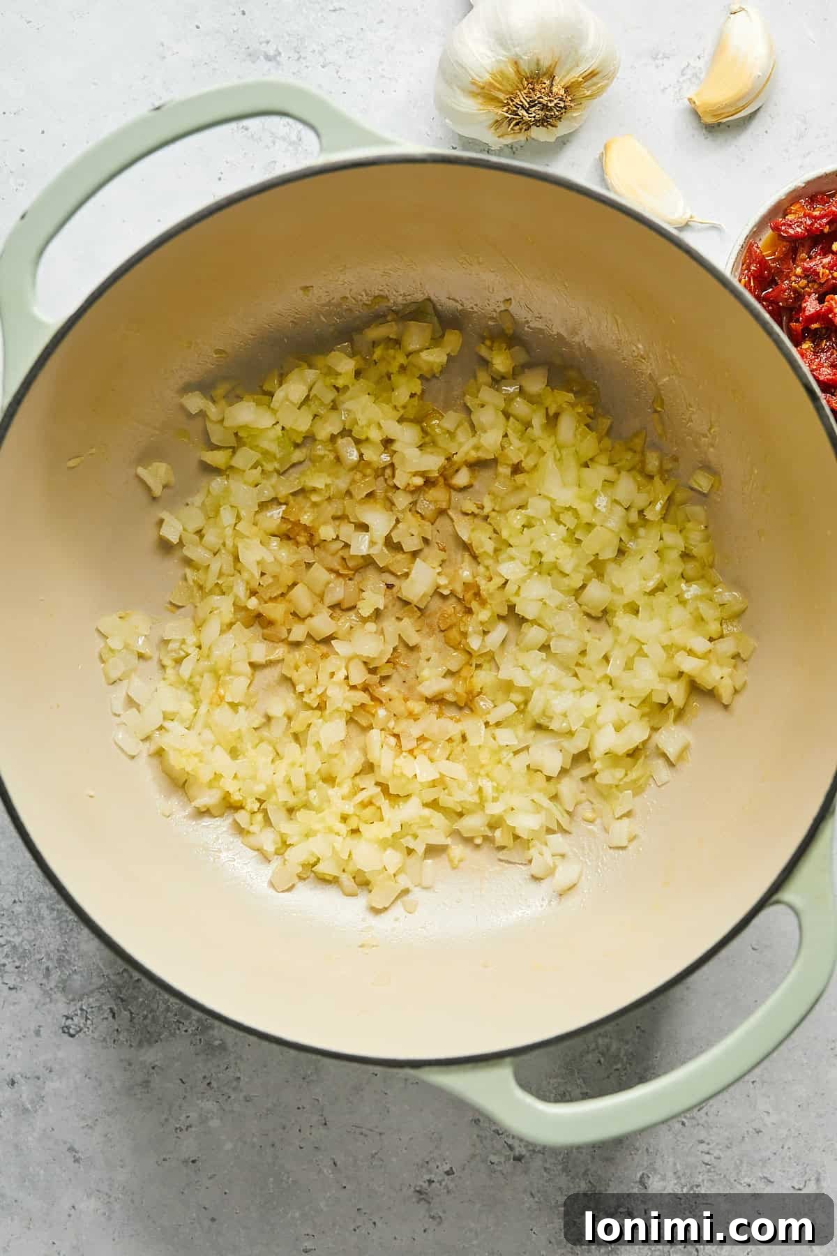Diced onions and minced garlic gently sautéing in olive oil in a large stock pot, filling the kitchen with fragrant aromas.