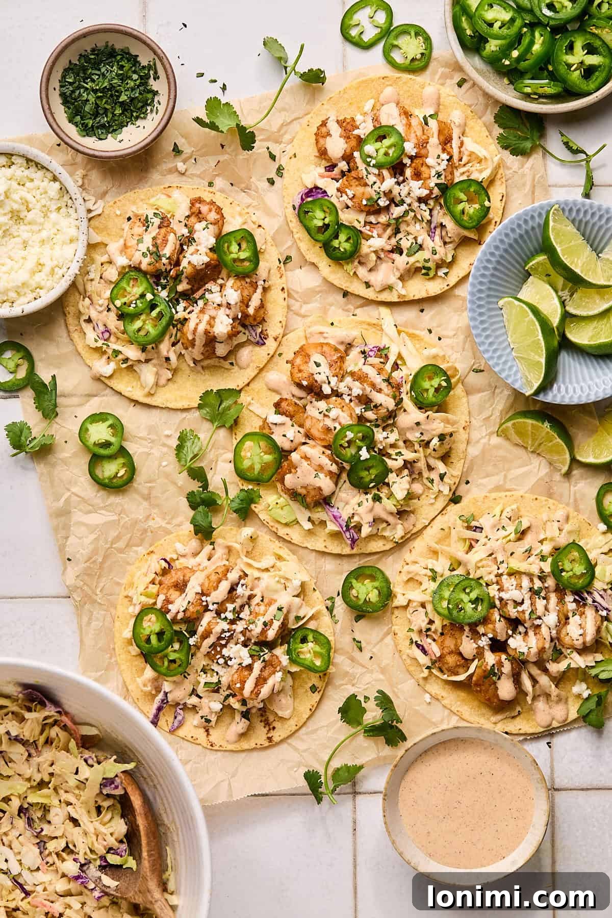 A delightful spread of Baja shrimp tacos laid out on a sheet of parchment paper, ready to be served and enjoyed.