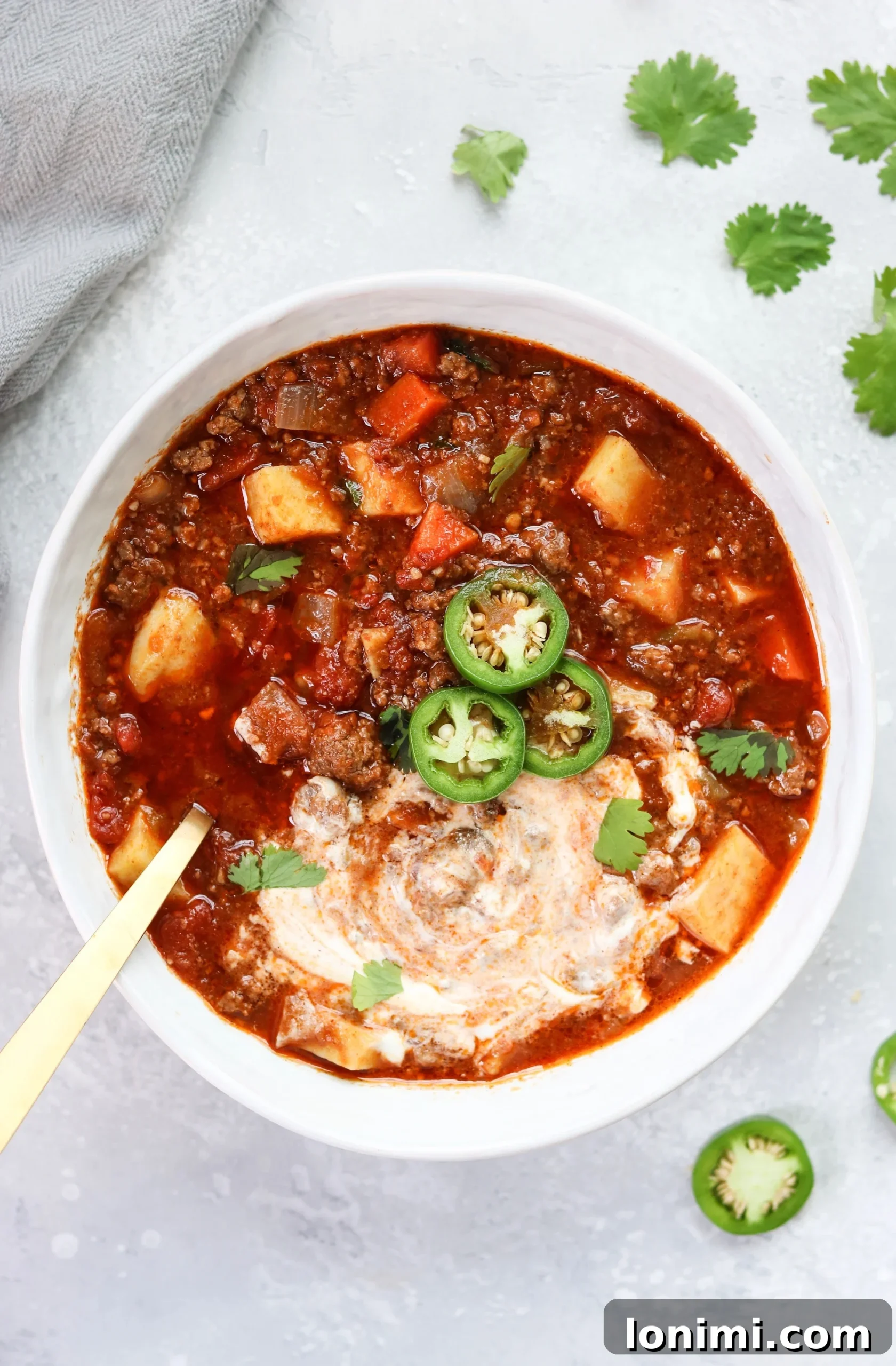Close-up of Slow Cooker Sweet Potato Chili with rich color and visible chunks of sweet potato and beef.