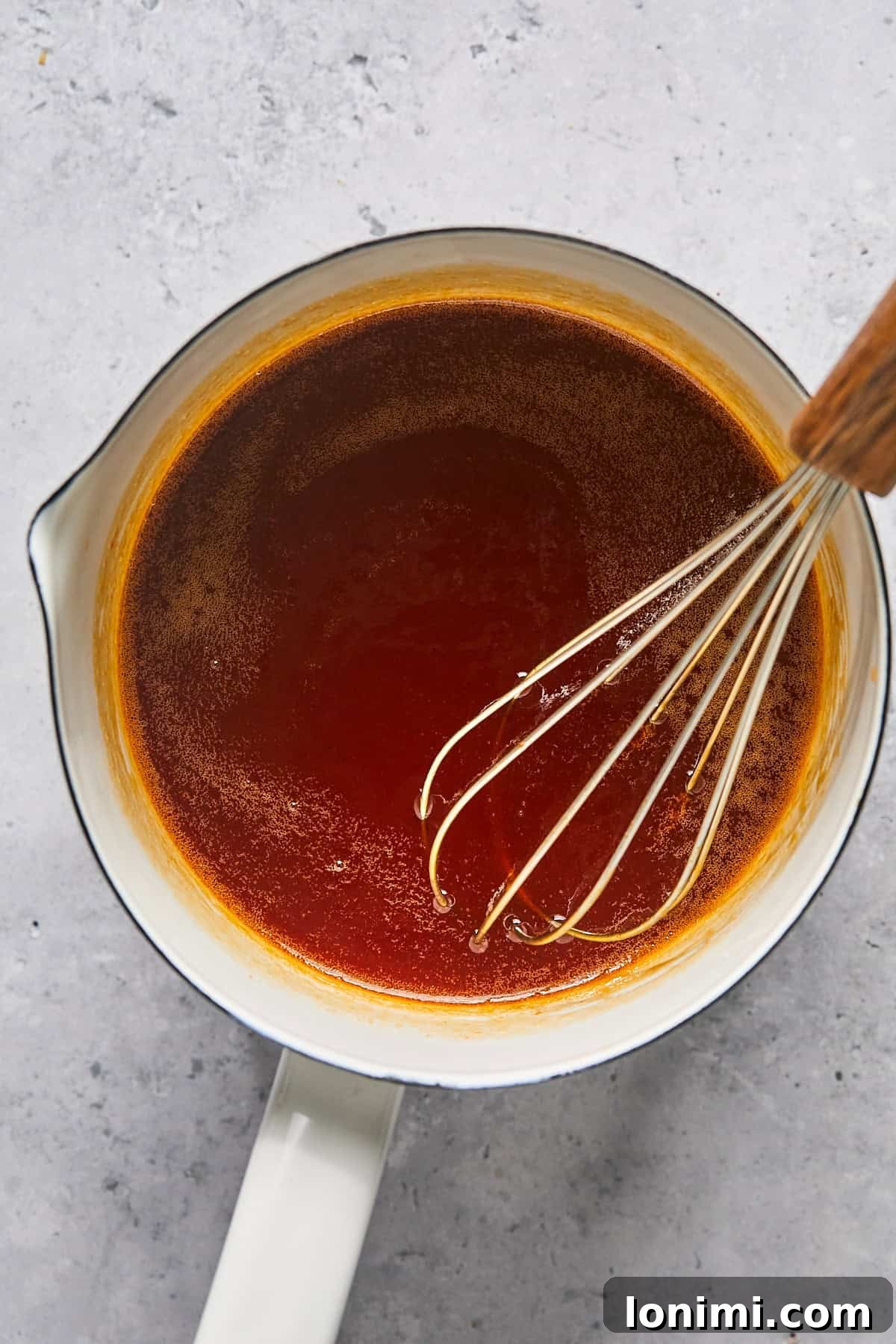 hot honey sauce in a pan with a whisk