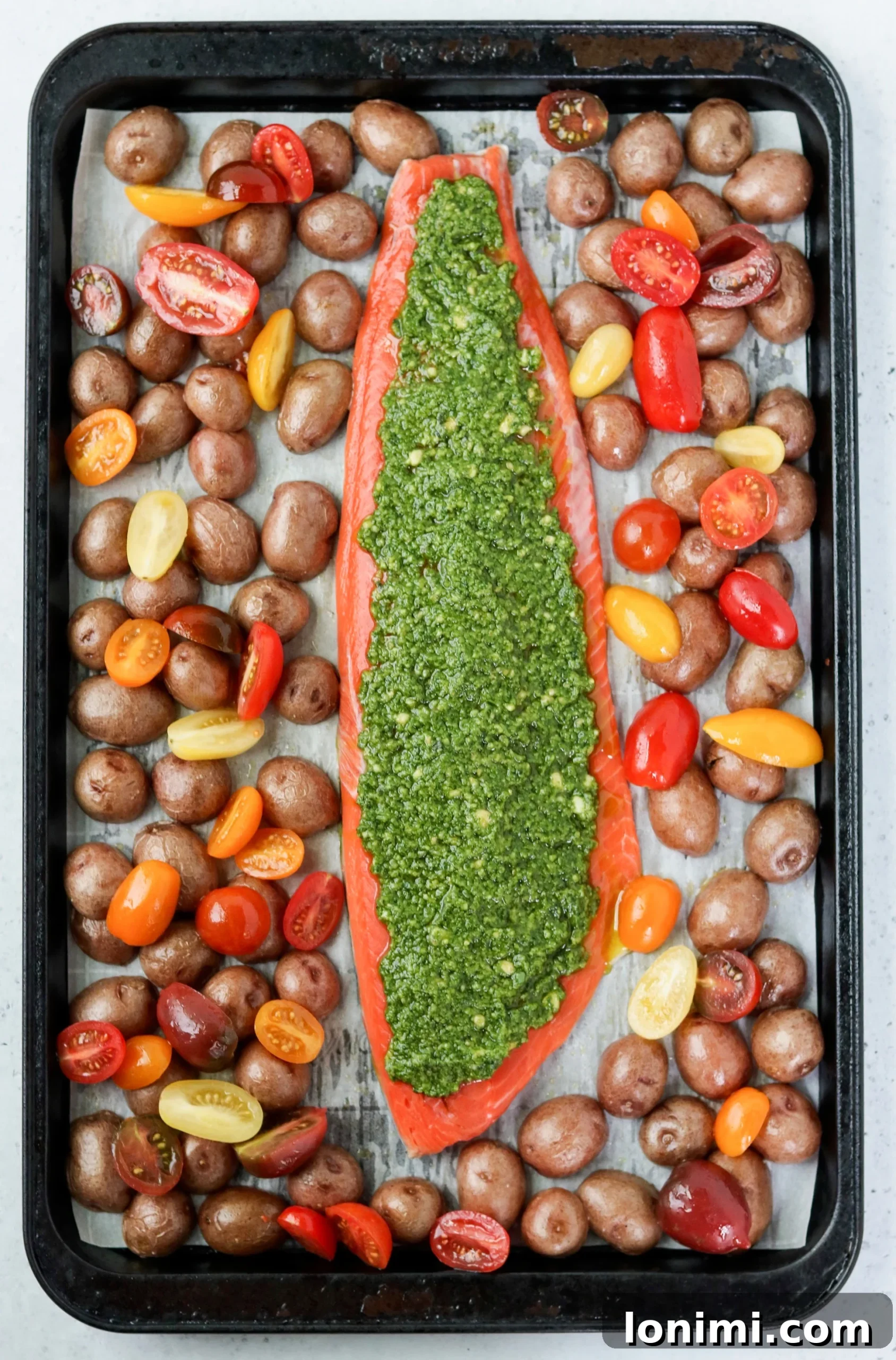 Close-up of perfectly cooked Sheet Pan Pesto Salmon with vibrant green pesto.