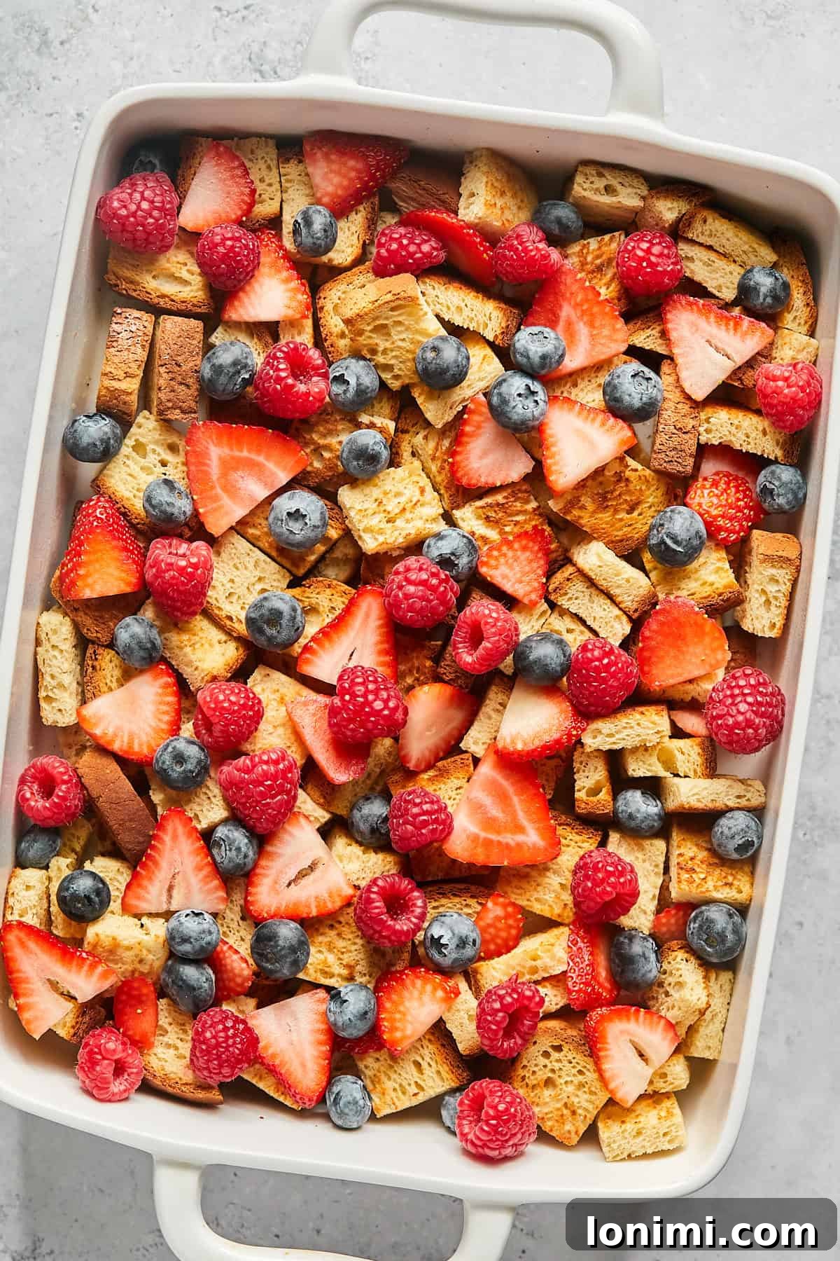 bread cubes and berries in a casserole dish