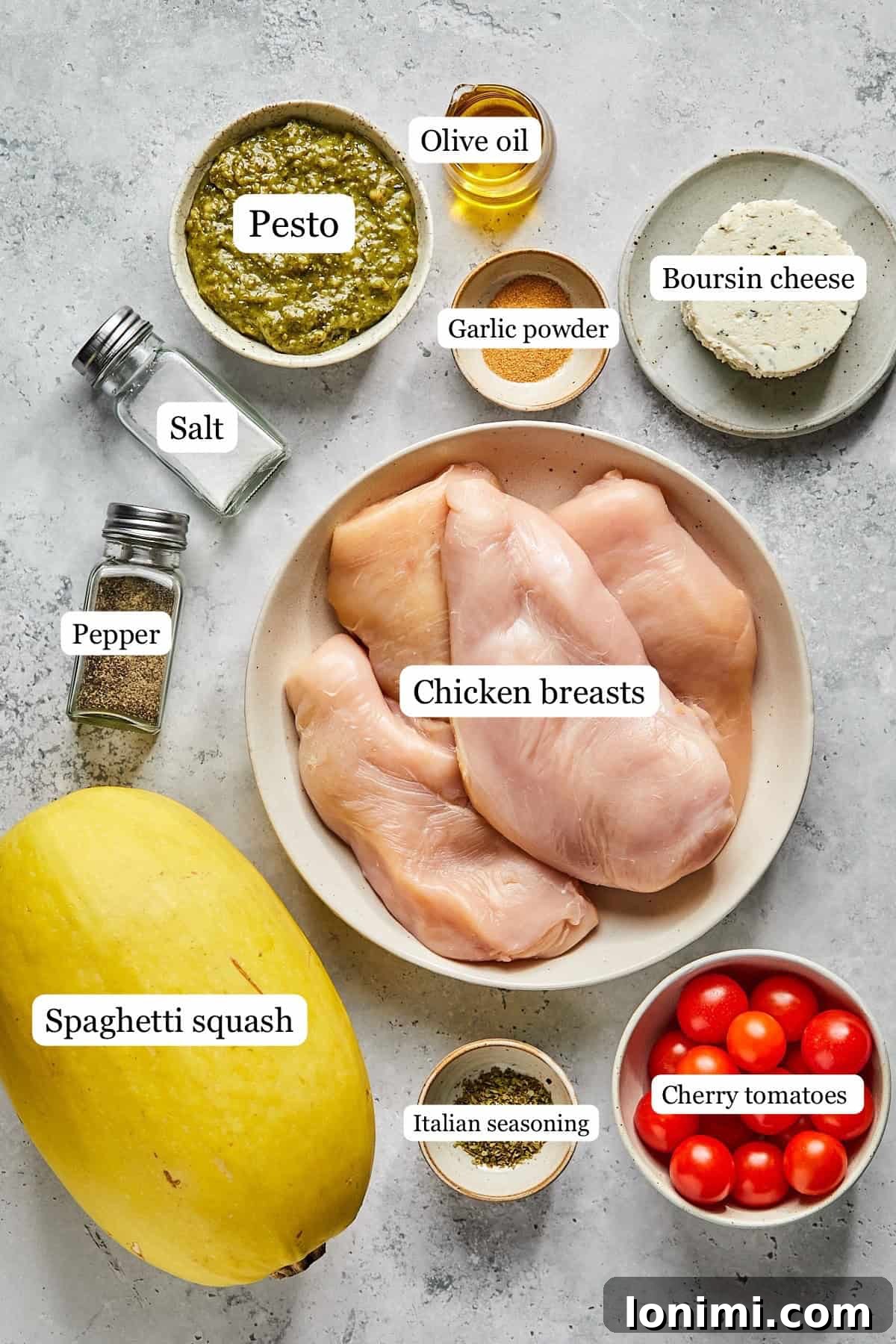 Small bowls containing the essential ingredients for the creamy Boursin chicken bake: chicken breasts, Boursin cheese, cherry tomatoes, olive oil, and various seasonings.