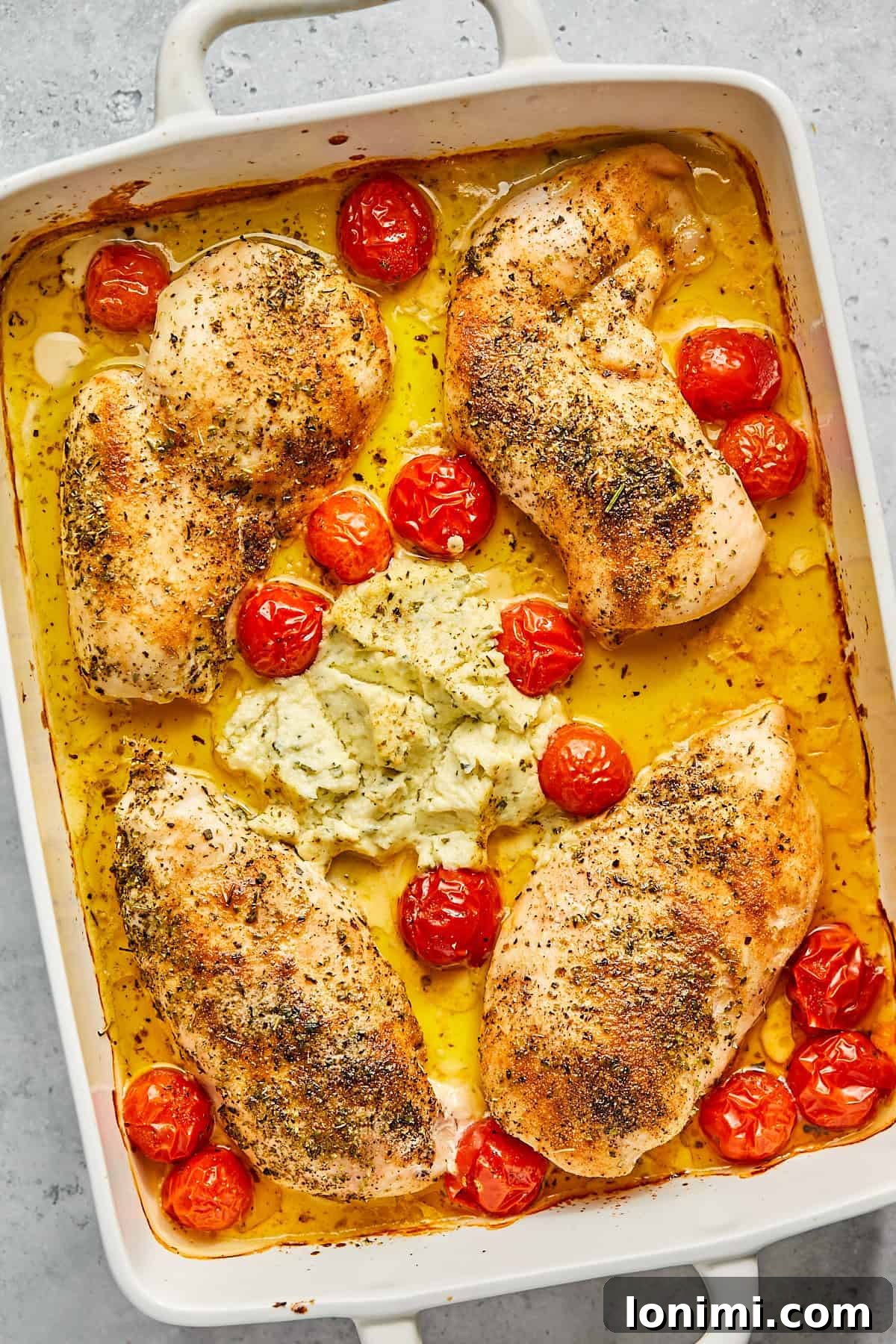 The golden-brown, baked Boursin chicken in a casserole dish, with melted cheese and roasted tomatoes, freshly out of the oven.
