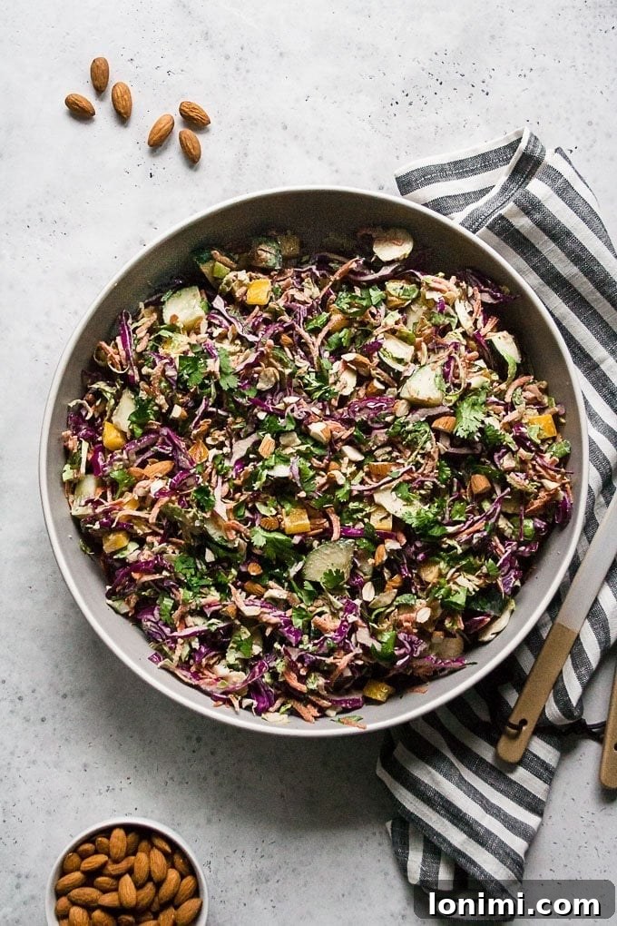 A vibrant Chopped Thai Brussels Sprouts Salad with a rich, creamy almond ginger dressing, presented in a large bowl.