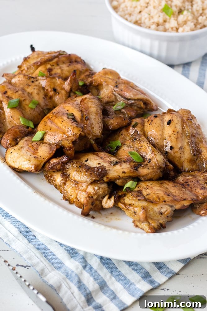 Perfectly grilled teriyaki chicken thighs, glazed and garnished, serving as a delicious gluten-free and paleo main course.