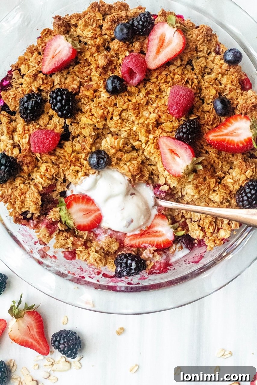 A warm, inviting Gluten-Free Berry Crisp, bubbling with fruit and topped with a golden, crunchy oat topping.