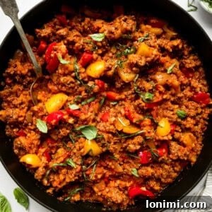 A deconstructed stuffed pepper in a black skillet with peppers and ground beef
