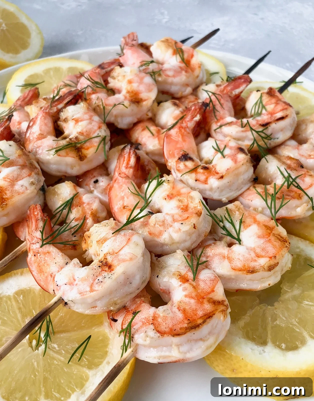 Grilled garlic butter dill shrimp over a bed of lemon slices and fresh dill