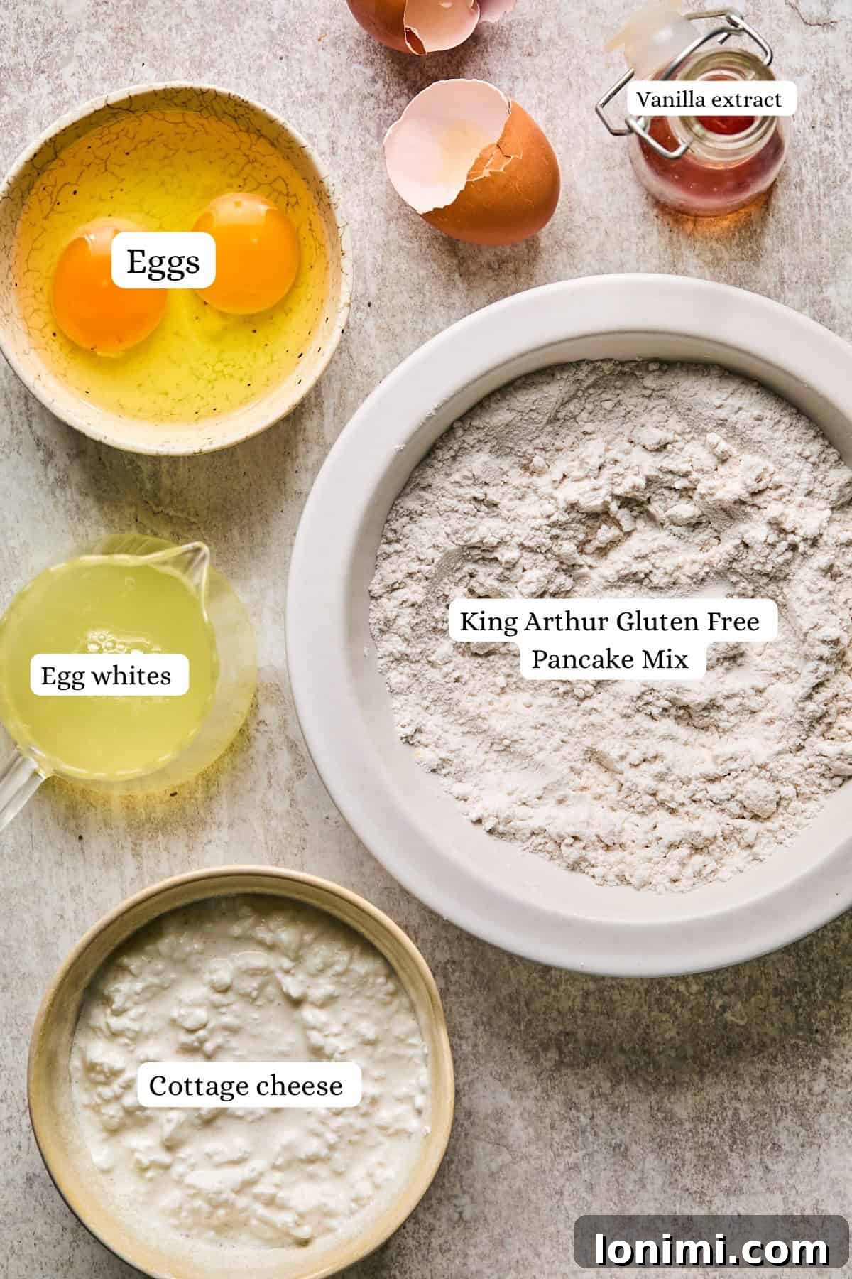 Ultimate Cottage Cheese Protein Pancakes 3 All the essential ingredients for making cottage cheese protein pancakes laid out on a kitchen counter, including eggs, liquid egg whites, pancake mix, and cottage cheese, ready for blending.