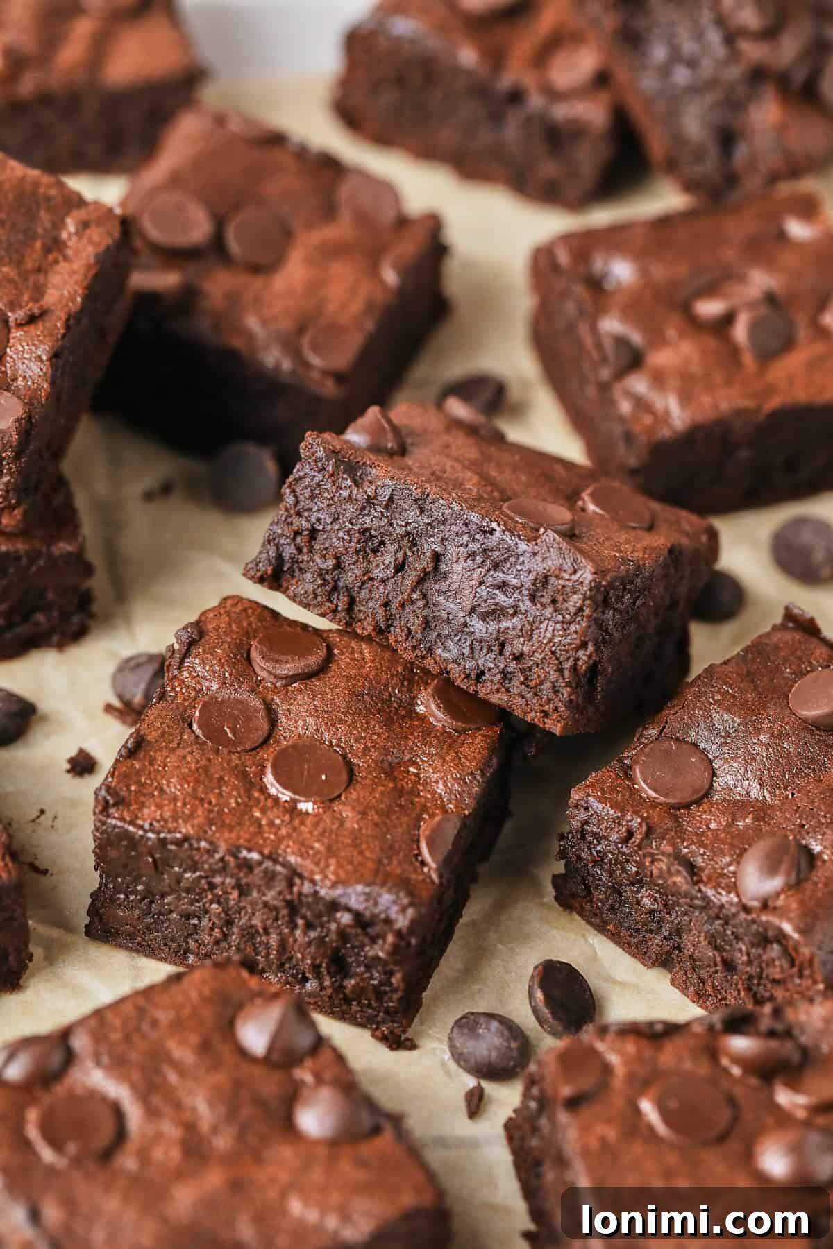 Rich Fudgy Protein Brownies With 7g Protein And A Clean Taste 11 fudgy brownies sliced and stacked near each other on parchment paper
