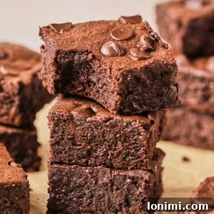Rich Fudgy Protein Brownies With 7g Protein And A Clean Taste 12 protein brownies stacked up on parchment paper