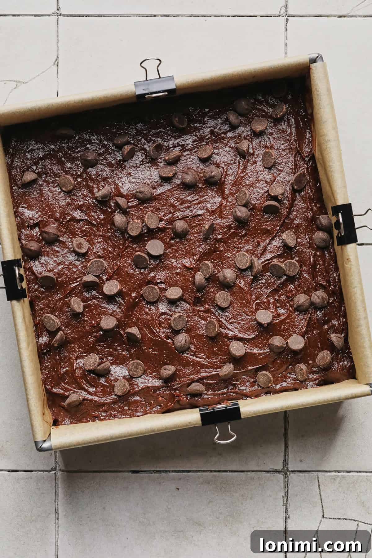 Rich Fudgy Protein Brownies With 7g Protein And A Clean Taste 8 Spreading protein brownie batter into a baking pan and topping with chocolate chips before baking