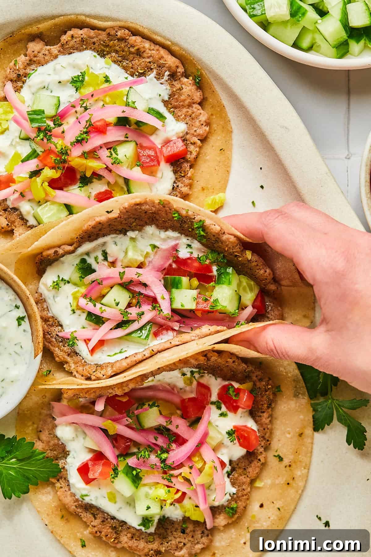 a hand holding turkey smash burger tacos