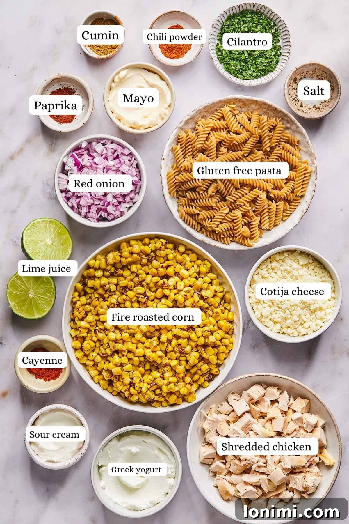 Neatly arranged ingredients for street corn pasta salad in nesting bowls, ready for preparation.