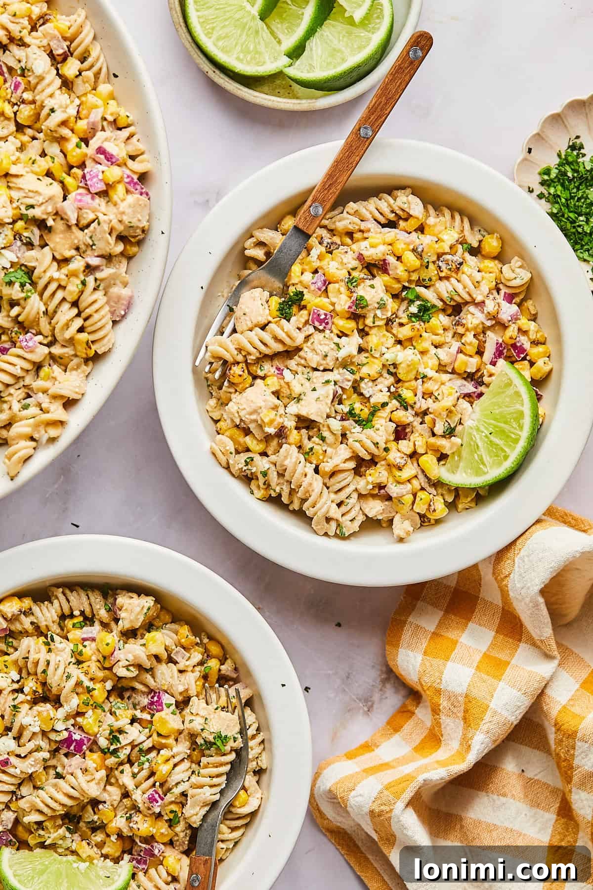 Three individual bowls of vibrant Street Corn Pasta Salad, perfectly portioned and ready to be enjoyed.